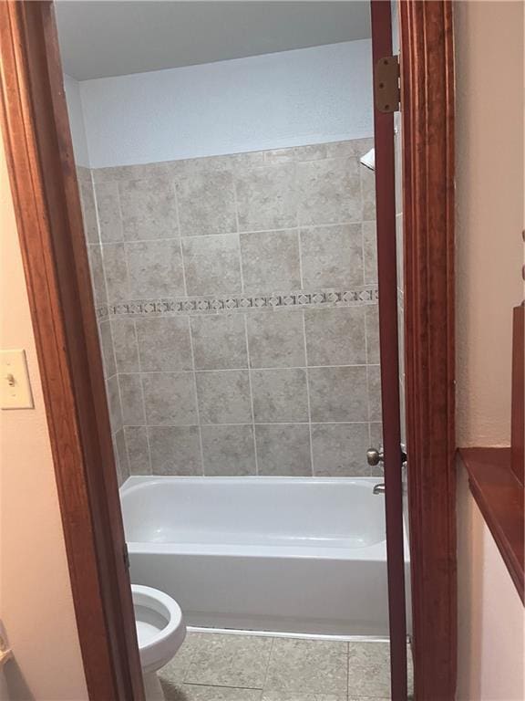 bathroom with tile patterned flooring, toilet, and shower / washtub combination
