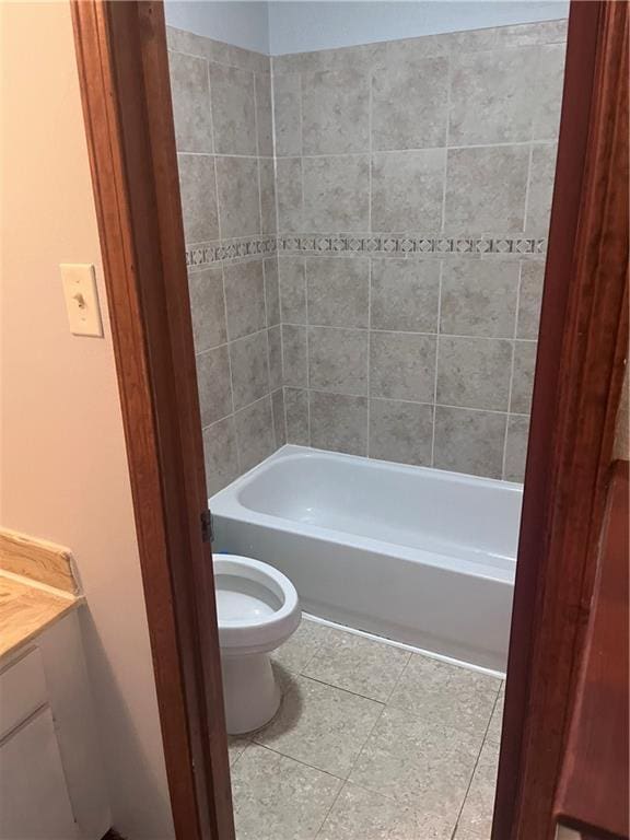 bathroom featuring tile patterned floors, toilet, vanity, and tub / shower combination