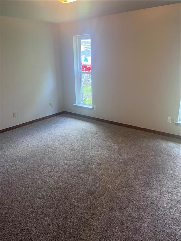 carpeted spare room with baseboards
