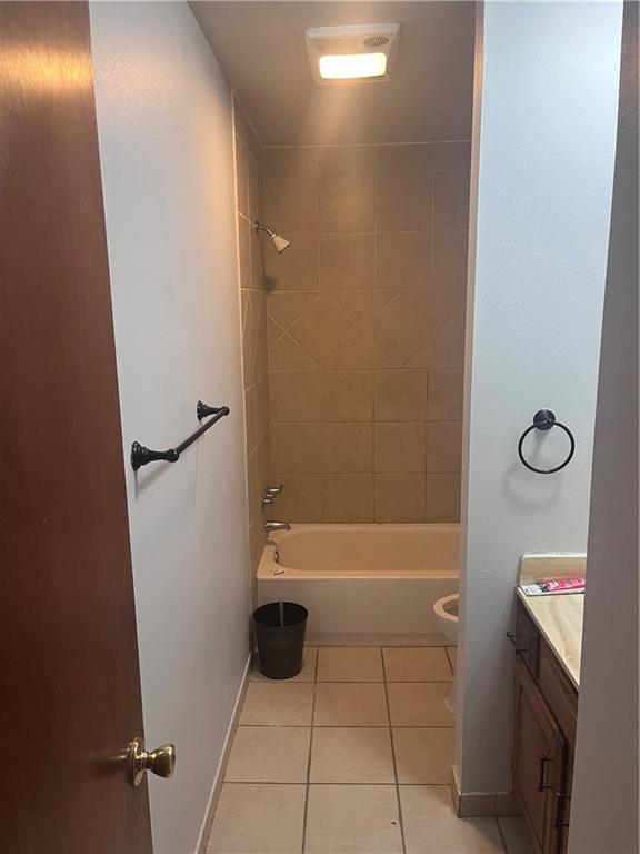 bathroom featuring tile patterned flooring, vanity, shower / bath combination, toilet, and baseboards