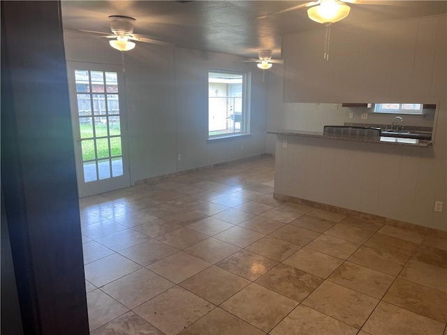 unfurnished room with a ceiling fan, healthy amount of natural light, and a sink