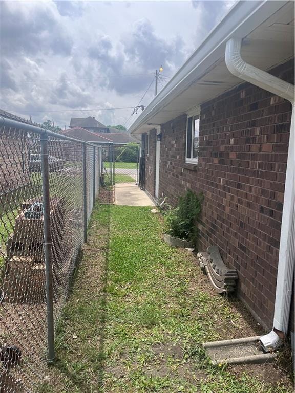 view of home's exterior featuring fence, a gate, and brick siding