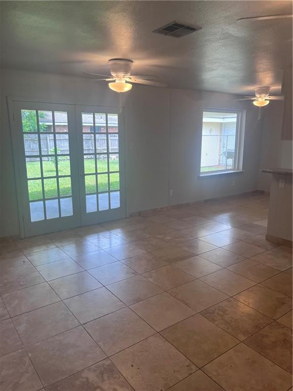spare room with ceiling fan, light tile patterned floors, and a textured ceiling