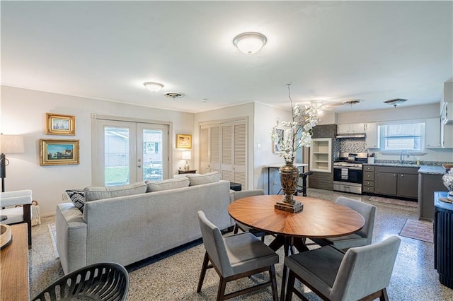 dining area featuring french doors and light speckled floor