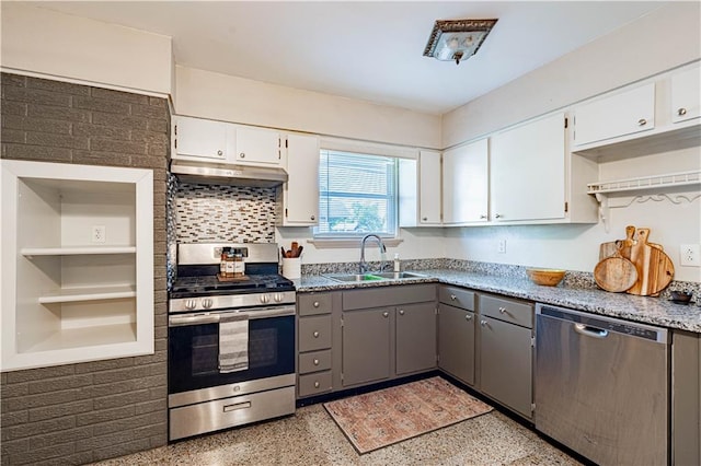 kitchen featuring under cabinet range hood, appliances with stainless steel finishes, a sink, and light speckled floor