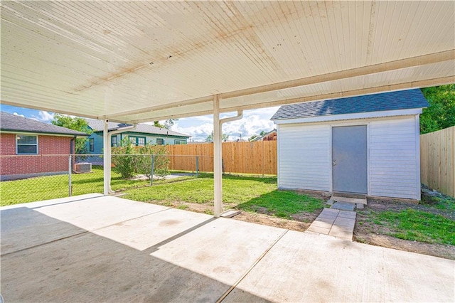 view of patio with a fenced backyard, a storage unit, and an outbuilding