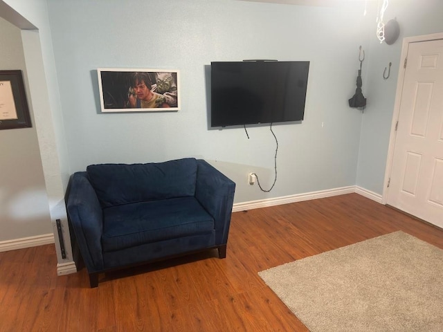 living area featuring baseboards and wood finished floors