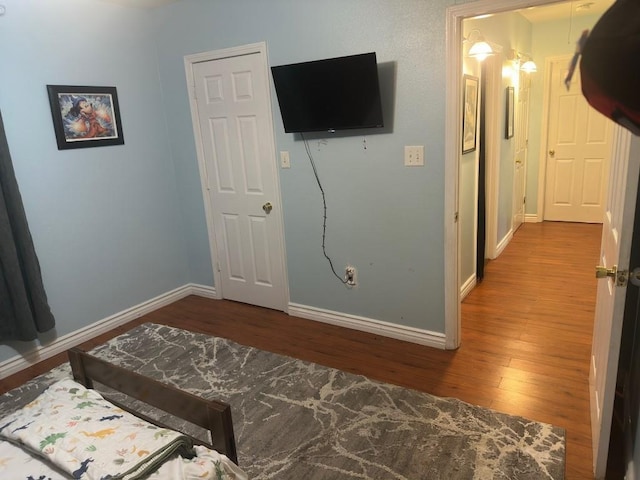 bedroom featuring baseboards and wood finished floors