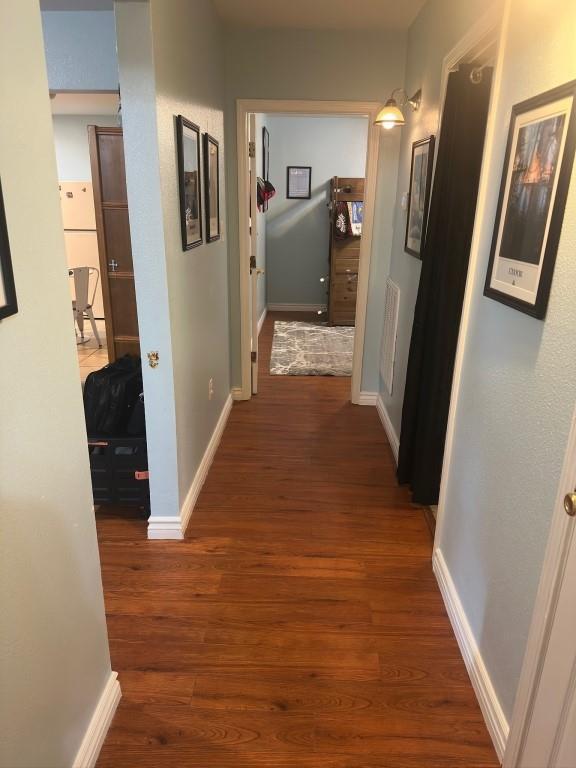 hallway with baseboards and wood finished floors