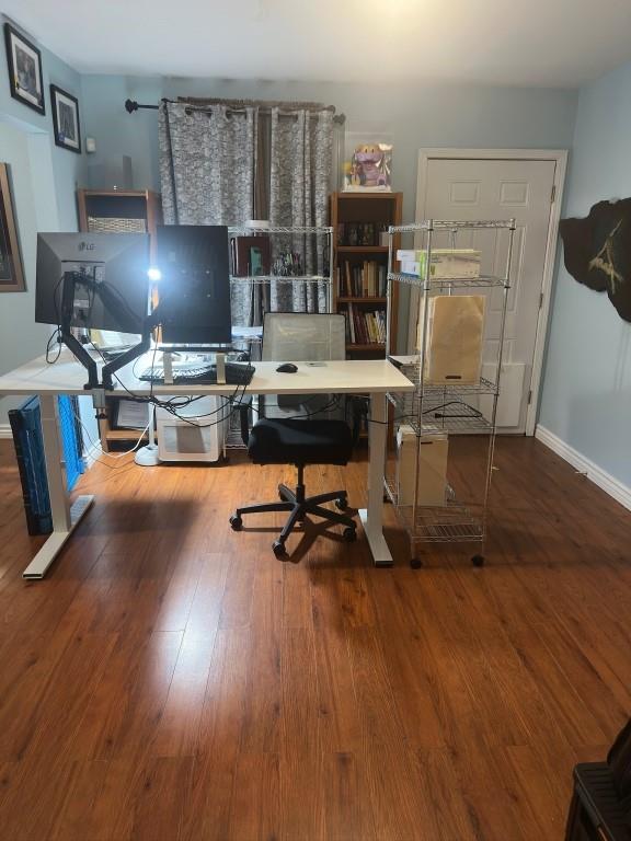 home office featuring baseboards and wood finished floors