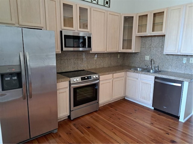 1131 Burgundy St Unit B, New Orleans, LA 70116 - kitchen with a sink, stainless steel appliances, decorative backsplash, wood finished floors, and glass insert cabinets