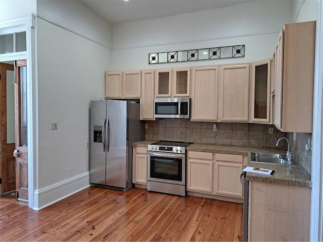 1131 Burgundy St Unit B, New Orleans, LA 70116 - kitchen featuring light wood-type flooring, a sink, tasteful backsplash, and stainless steel appliances
