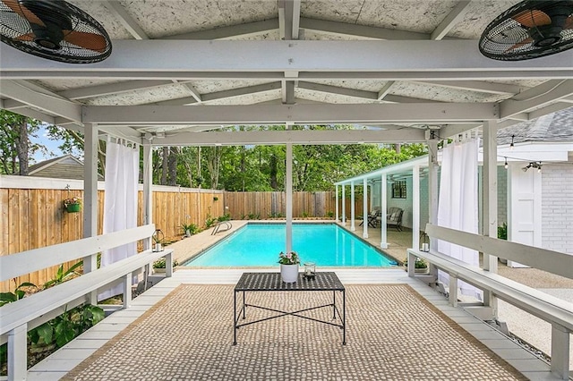 view of pool featuring a fenced in pool, a fenced backyard, ceiling fan, and a patio