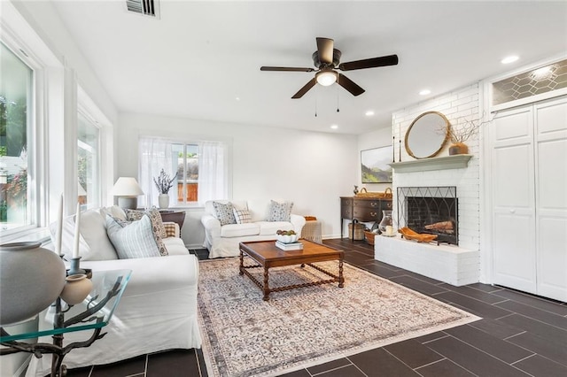 living area featuring ceiling fan, a brick fireplace, recessed lighting, and visible vents
