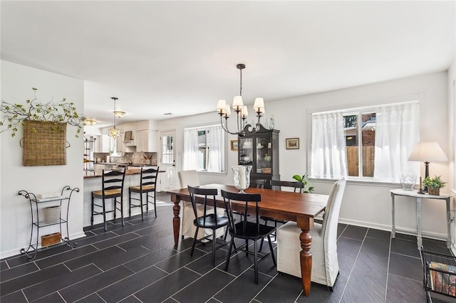 dining area with baseboards and a notable chandelier