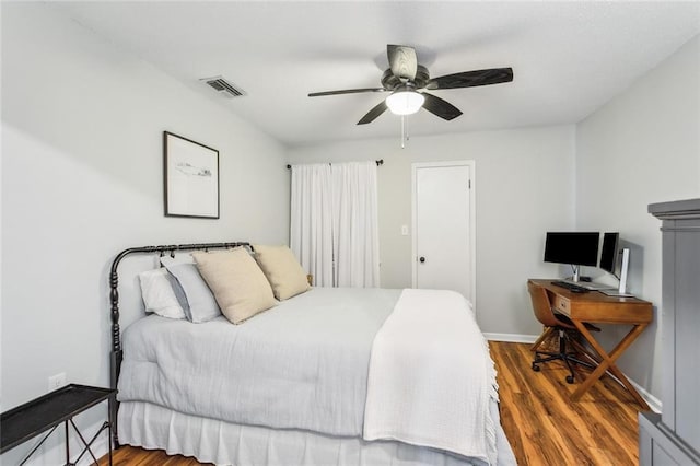 bedroom with visible vents, baseboards, ceiling fan, and wood finished floors