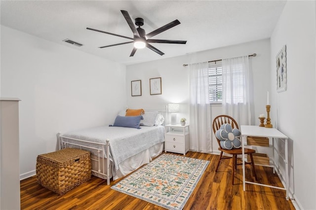 bedroom featuring visible vents, a ceiling fan, and wood finished floors