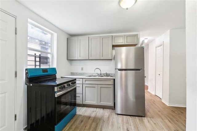 1772 N Dorgenois St, New Orleans, LA 70119 - kitchen featuring light wood-style floors, a sink, gray cabinetry, and stainless steel appliances