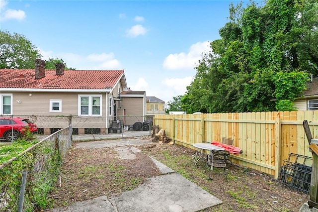 1772 N Dorgenois St, New Orleans, LA 70119 - back of property with a fenced backyard, a tiled roof, and a chimney