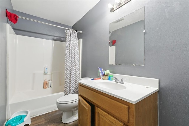 full bath with vanity, wood finished floors, toilet, and shower / bath combo with shower curtain