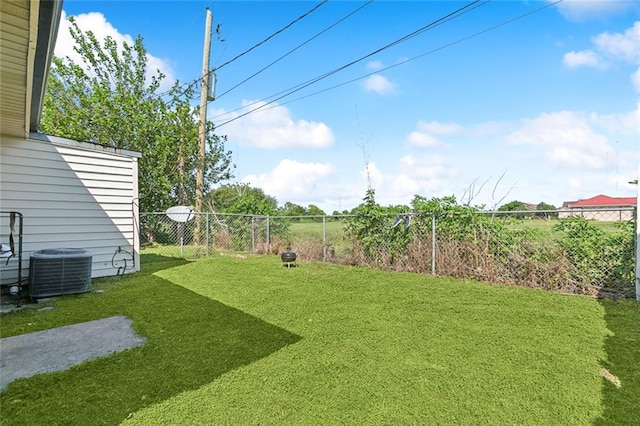 view of yard with a fenced backyard and central AC