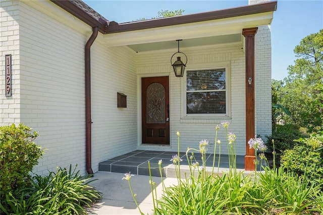 doorway to property featuring brick siding