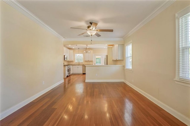 unfurnished living room featuring crown molding, baseboards, wood finished floors, and ceiling fan with notable chandelier