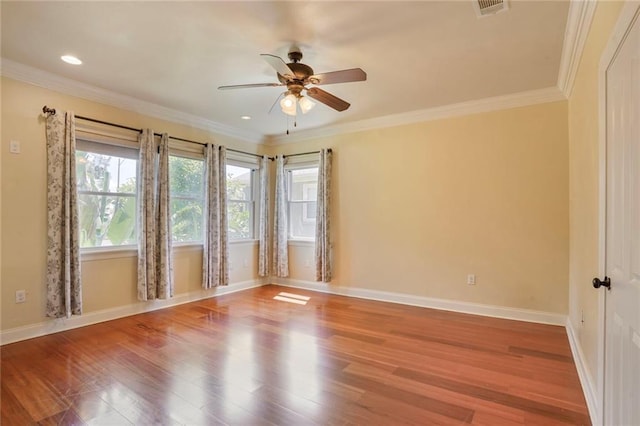 empty room featuring baseboards, ceiling fan, visible vents, and wood finished floors