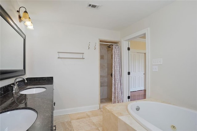 bathroom featuring visible vents, a sink, a tile shower, and a jetted tub