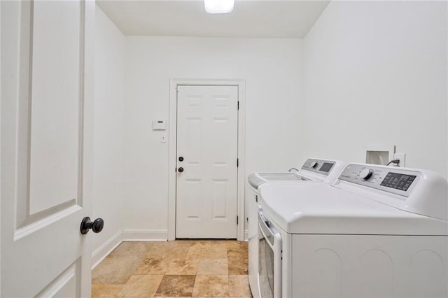 washroom featuring laundry area, baseboards, and washing machine and clothes dryer