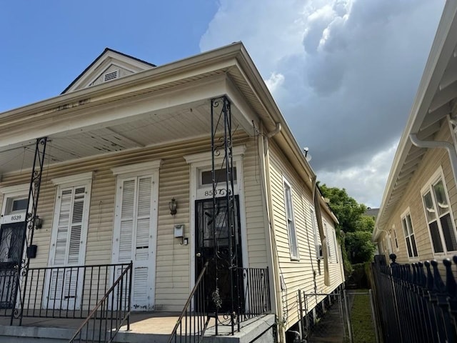 shotgun-style home featuring fence and a porch