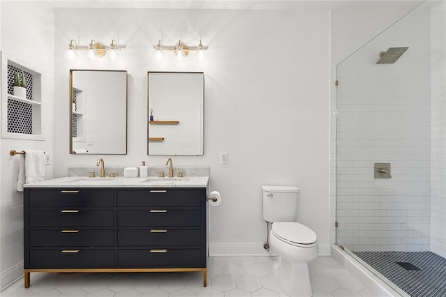bathroom featuring baseboards, a sink, a stall shower, and toilet