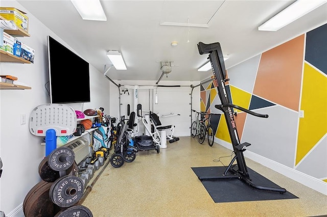 exercise room featuring baseboards and attic access