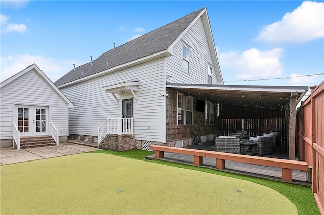 rear view of property featuring french doors, a patio area, and roof with shingles