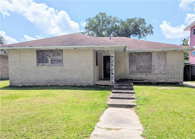 single story home featuring brick siding and a front yard