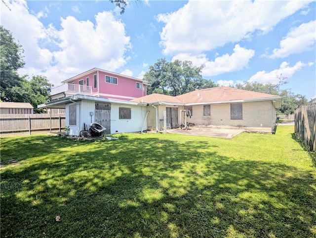 rear view of property with a lawn, a fenced backyard, and a patio area