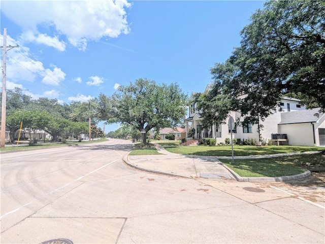 view of road with curbs, traffic signs, and sidewalks