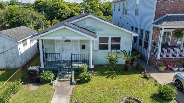 1336 Sere St, New Orleans, LA 70122 - bungalow-style home featuring a porch and a front yard