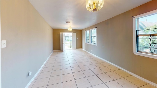 1336 Sere St, New Orleans, LA 70122 - empty room with visible vents, baseboards, light tile patterned floors, and a chandelier