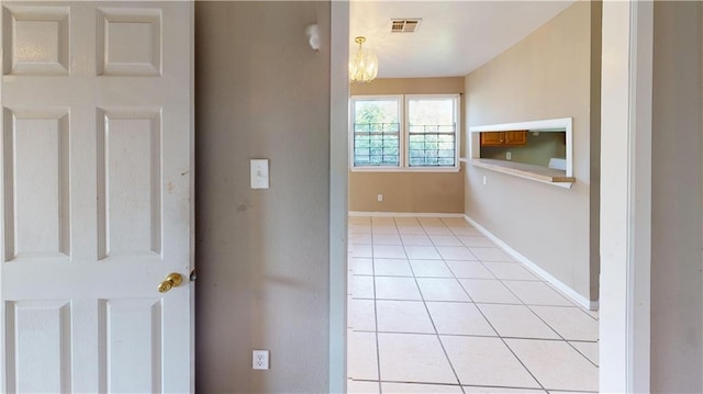 1336 Sere St, New Orleans, LA 70122 - hallway featuring baseboards, a notable chandelier, light tile patterned flooring, and visible vents