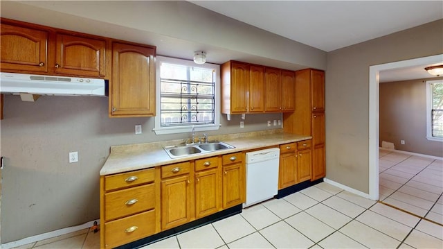 1336 Sere St, New Orleans, LA 70122 - kitchen with light countertops, brown cabinetry, under cabinet range hood, and dishwasher