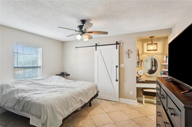 2967 Camellia Dr, Slidell, LA 70458 - bedroom featuring a barn door, a textured ceiling, a ceiling fan, baseboards, and light tile patterned floors