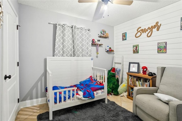 2967 Camellia Dr, Slidell, LA 70458 - bedroom featuring a ceiling fan, a textured ceiling, light tile patterned floors, and wooden walls