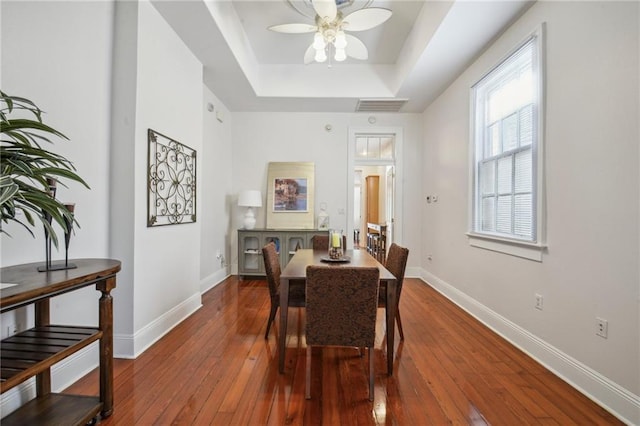192426 Esplanade Ave, New Orleans, LA 70116 - dining space featuring ceiling fan, wood-type flooring, baseboards, a tray ceiling, and visible vents