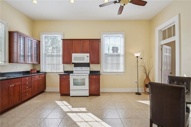 192426 Esplanade Ave, New Orleans, LA 70116 - kitchen featuring dark countertops, white appliances, baseboards, ceiling fan, and recessed lighting