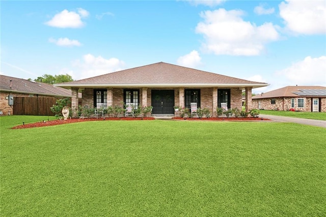 view of front of home with fence, a porch, brick siding, and a front yard