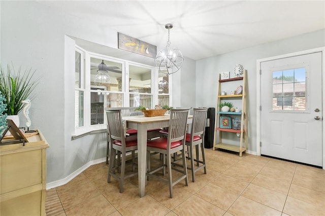 dining area featuring an inviting chandelier, light tile patterned floors, and baseboards