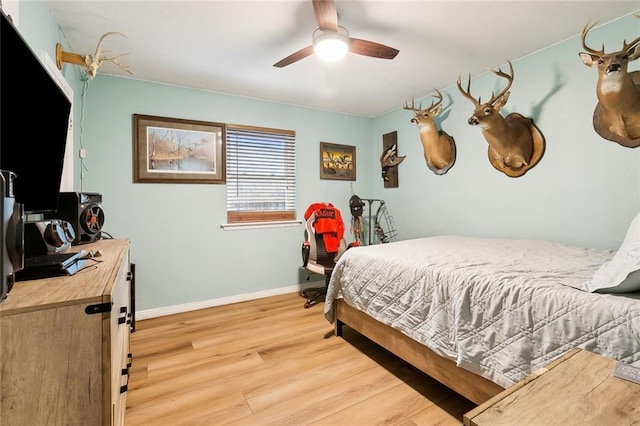 bedroom featuring baseboards, ceiling fan, and light wood-style flooring