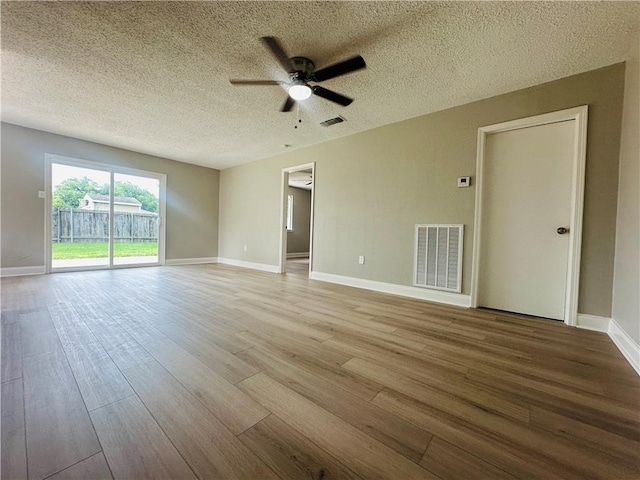 unfurnished room featuring a ceiling fan, visible vents, and wood finished floors