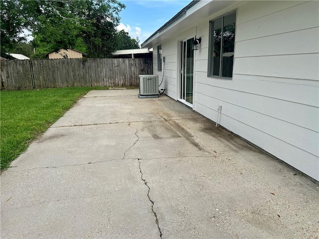 view of patio with central air condition unit and fence